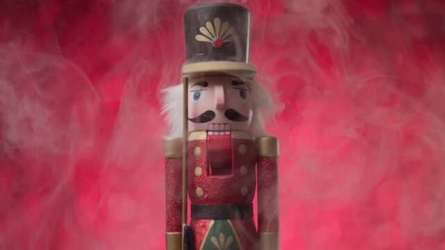 Toy Nutcracker standing on red bokeh background, surrounded by smoke, beautiful scene