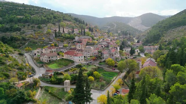Aerial view of Dol, a picturesque village nestled in a lush valley on Brac Island, Croatia. Autumn colors highlight the traditional stone houses and terraced hillsides.