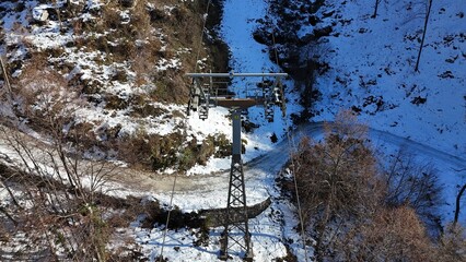 Aerial drone view of snowy mountain cableway towers