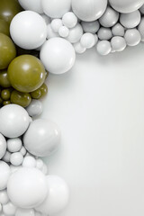 Minimalist balloon garland in white and olive tones forming a corner frame on a clean light background, perfect for celebrations, party decor, event branding and modern design layouts.