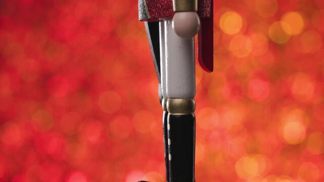 Full body presenatation of a spinning Nutcracker on a beautiful bokeh red and orange background