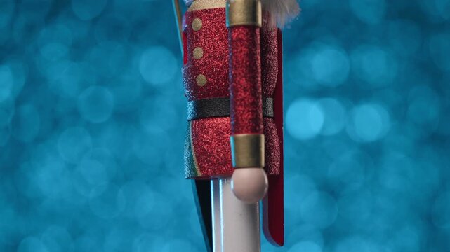 Little statuette of the Nutcracker is spinning on a cool blue bokeh background
