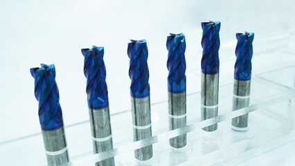 Blue coated end mills or cutting tools  in a transparent acrylic display rack.