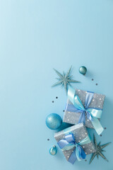 Two blue Christmas gifts, ornaments on light blue background. Flat lay, top view, vertical