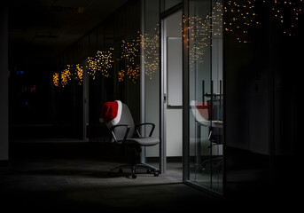 Corporate office corridor with christmas lights and Santa hat on chair, festive workplace holiday spirit