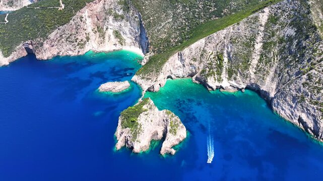 Aerial drone video of not so famous paradise bay and caves of Saint Andrews islet creating a blue lagoon visited by yachts and small boats in the Northern part of Zakinthos island, Ionian Sea, Greece