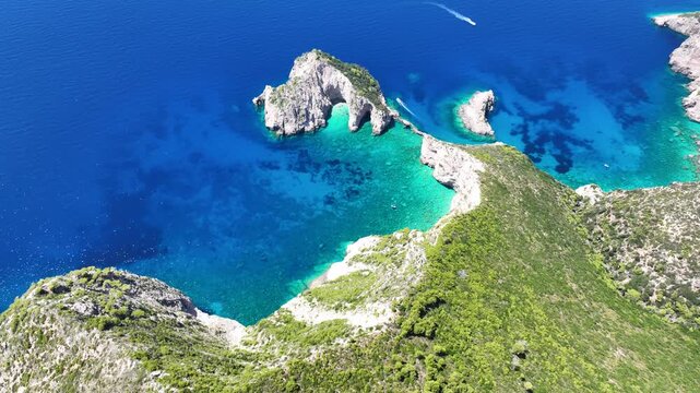 Aerial drone video of not so famous paradise bay and caves of Saint Andrews islet creating a blue lagoon visited by yachts and small boats in the Northern part of Zakinthos island, Ionian Sea, Greece