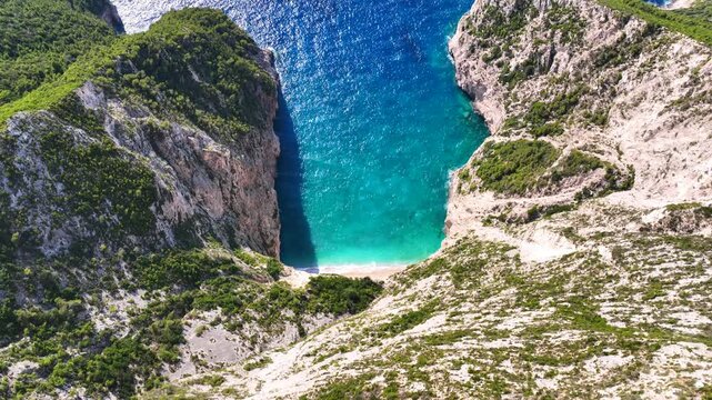 Aerial drone video of not so famous paradise bay and caves of Saint Andrews islet creating a blue lagoon visited by yachts and small boats in the Northern part of Zakinthos island, Ionian Sea, Greece