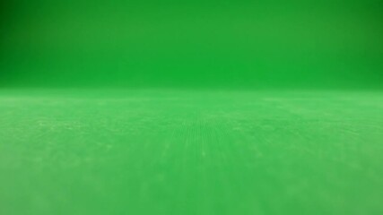 Green screen studio background with textured floor and curved wall
