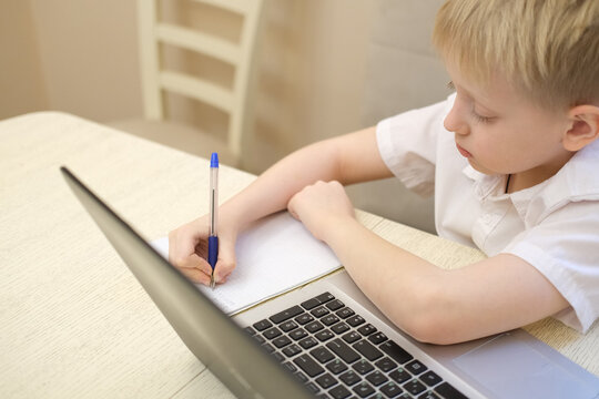 Young boy studying homework with laptop for online education