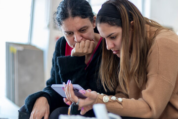 Women discussing shared content on a smartphone