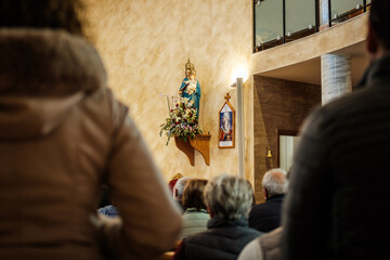 Statue of the Virgin Mary Adorned with Flowers in a Church