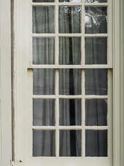 Close up of an antique white twelve pane window in historic Dover Delaware
