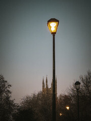 Mood and Light: Streetlamp Glow Against Church Spire Silhouette and Metal Railing Pathway, Burton, UK