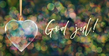 Poczt&oacute;wka bożonarodzeniowa - przezroczysta bombka choinkowa w kształcie serca na tle kolorowych rozmyć świateł bokeh z napisem Merry Christmas w języku norweskim