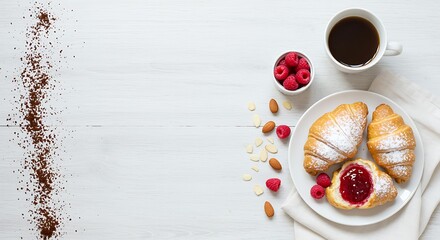 Delicious breakfast with croissants raspberries coffee and almonds on white wood
