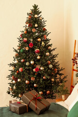 Festively decorated Christmas tree stands next to beautifully wrapped gifts in a cozy indoor setting