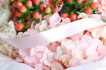 Elegant floral arrangement with pink hydrangeas, red hypericum berries, and white ribbon, perfect for wedding or romantic decor
