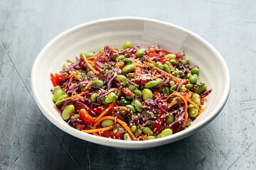 Healthy Edamame Salad with carrots, bell peppers, red cabbage, green onion and sesame seeds.