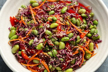 Healthy Edamame Salad with carrots, bell peppers, red cabbage, green onion and sesame seeds.