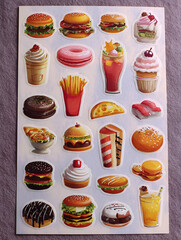  Collection of small, cute cartoon photo stickers featuring various comfort foods like burgers, fries, and desserts arranged on a sheet.