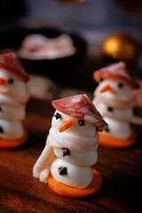 Obraz premium Mozzarella balls with sausage, bacon and carrot slices in the form of snowman for Christmas holidays