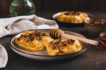 Baked pumpkin with brie cheese, nuts, rosemary and honey on a plate on the table