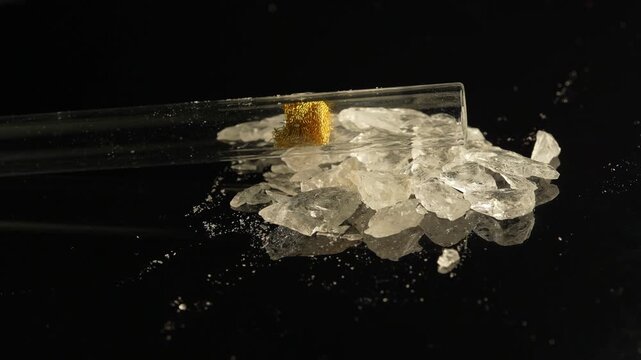 Crystal meth drug in rocks with smoking crack pipe on the table of addict. Addiction and drugs trafficking. Illicit drugs very potent and addictive, substances altered for street sale by drug dealer.