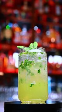 Mojito with mint and ice. A tall glass of mojito filled with mint leaves, ice and sparkling lime mixture.