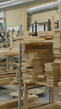 Stacked lumber fills a warehouse, neatly organized on shelving. Concept of resourcefulness, construction, or sustainable forestry is conveyed.