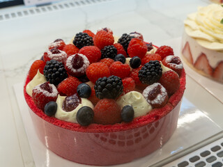 Delightful berry cake adorned with fresh fruits at a pastry shop display