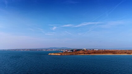 Flight over the blue waterscape of the Black Sea. A picturesque coastal cityscape on the shore.