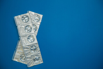Packages of daily disposable contact lenses in a disposable protective case in which clear lenses float lie on the side on a blue background with space for text. The concept of ophthalmology, vision