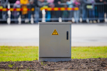 Electrical utility control cabinet with high voltage warning sign installed outdoors for power distribution infrastructure