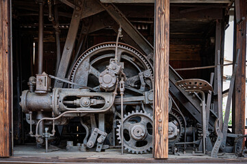 Detailed close-up of the complex steam engine mechanism of the excavator (1922), showing massive rusty gears, piston assembly, levers, and control seat.
