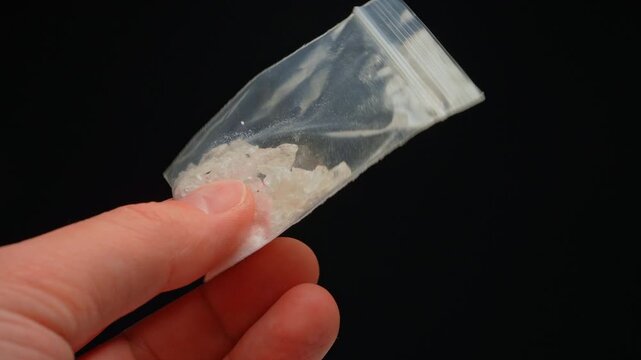 Drug dealer showing Fentanyl Crystal meth or Crack Cocaine for sale and distribution. Drug trafficking and addictioncrisis. Crystals use in glass tube or stems and primarily smoking or as powder.
