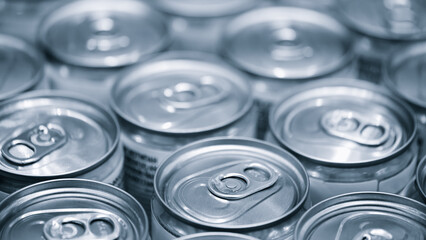 Row of aluminum cans for beer or other drinks on conveyor after pouring the drink inside close-up, industrial concept background