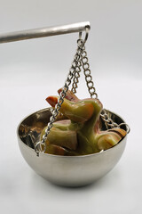 Jade rabbit figurine on balance scale symbolizing value weighing closeup.