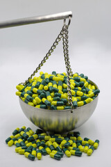 Capsules on balance scale symbolizing medical weight