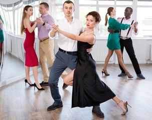 Pair of woman and man enjoying of sensual tango dance in choreo class. Exciting hobby, active...