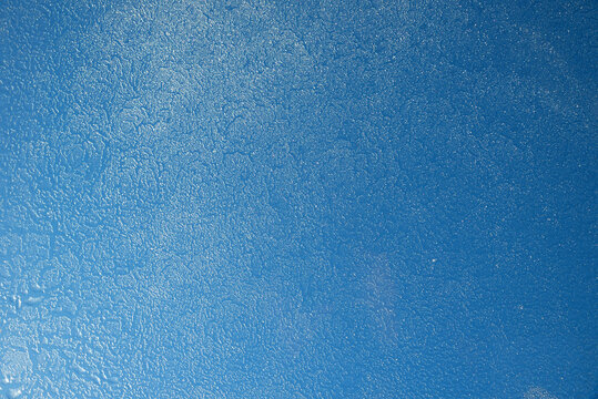 frosted glass of roof window with blue sky behind