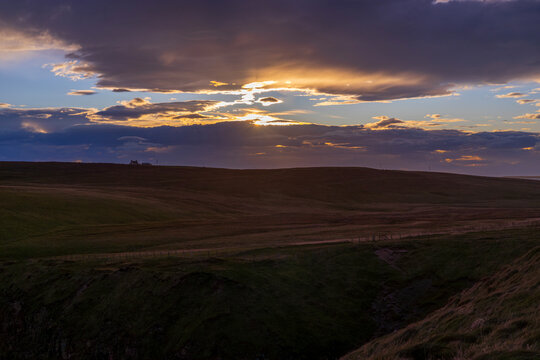Stunning gold and pink sunset over the Scottish moors of Knockan Crag nature reserve in northern Scotland.