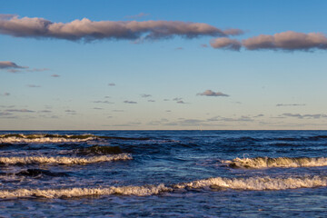 Waves of the Baltic Sea Under a Blue Sky and Pink Clouds at Sunset