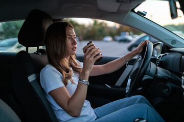 Woman enjoying coffee while driving a car