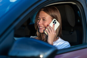 Young woman talking on smartphone while driving a car