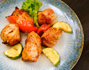 Chicken kebab skewers on a plate over light grey slate, stone or concrete background . Top view with copy space. High quality photo