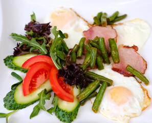 Breakfast with scrambled eggs, bacon and vegetable salad. High quality photo