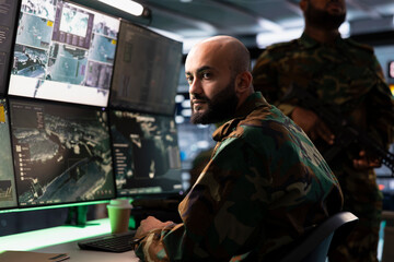 Army operative in control room analyzing surveillance data during global warfare. Middle Eastern intelligence agent in base of operations completes mission during World War 3 geopolitical operation
