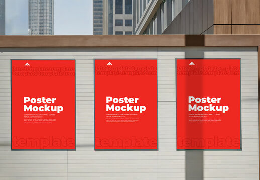 Triple Vertical Poster Mockups on a White Urban Barrier near a Glass Building
