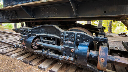 Naklejka premium Sierra Nevada Logging Museum looking a a vintage steam locomotive used to move timber from the mountains tho the sawmills showing the undercarriage of the engine